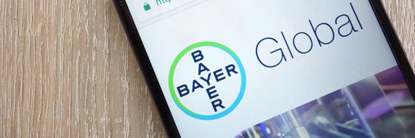 Smartphone zeigt das Bayer-Logo und das Wort "Global" auf einem Bildschirm.