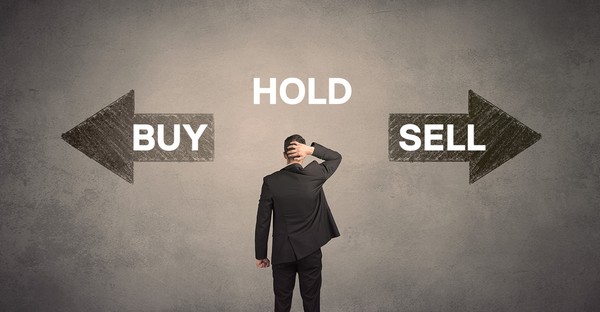 Mann im Anzug steht vor Pfeilen mit den Worten "Buy", "Hold" und "Sell".