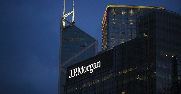 J.P. Morgan-Gebäude bei Nacht mit beleuchtetem Logo vor dunklem Himmel.