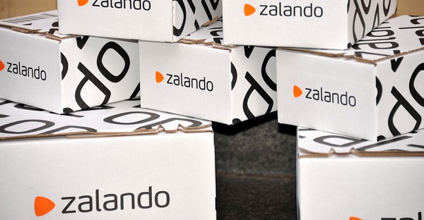 Mehrere gestapelte Zalando-Pakete mit dem Logo in Schwarz und Orange.
