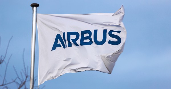 Weiße Flagge mit blauem Airbus-Logo weht im Wind vor blauem Himmel.
