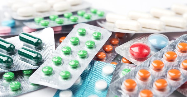 Verschiedene bunte Tabletten in Blisterverpackungen auf einem Haufen.