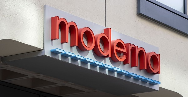 Schild mit dem roten Schriftzug "moderna" an einer Gebäudewand.