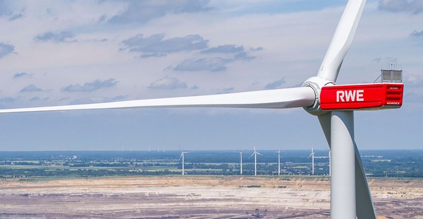 Windrad mit RWE-Logo vor Landschaft und mehreren Windrädern im Hintergrund.