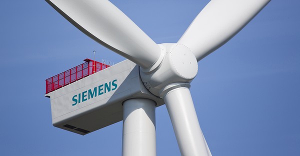 Nahaufnahme einer Siemens-Windturbine vor blauem Himmel.