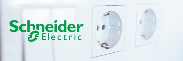 Schneider Electric-Logo neben zwei weißen Steckdosen auf einer weißen Wand.