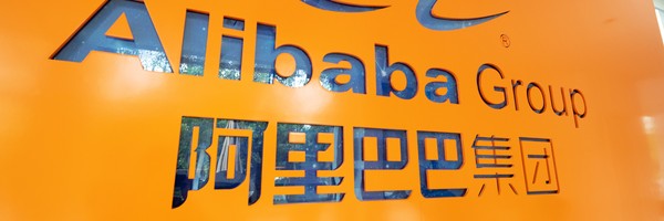 Orange Wand mit dem Schriftzug "Alibaba Group" und chinesischen Zeichen darunter.